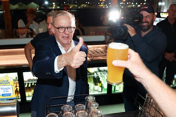 Cheers: Albanese gives a thumbs up to a patron after pouring them a beer in Fremantle.