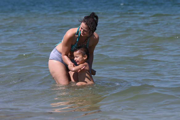 Sharlene Piggott and her two-year-old son, Jordan, getting some relief from the heat on Friday. 