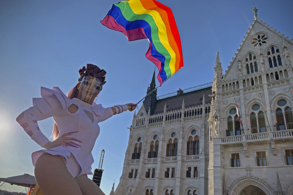 A drag queen waves a rainbow flag during an LGBT rights demonstration in front of the Hungarian Parliament building in Budapest, Hungary on June. 14, 2021. 