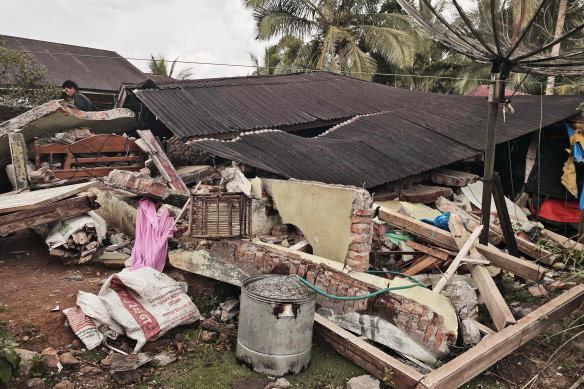 A man inspects a damaged house following an earthquake in Talamau, West Sumatra, Indonesia, on Friday.