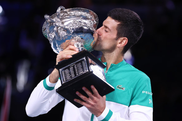Novak Djokovic savours the moment with the trophy.