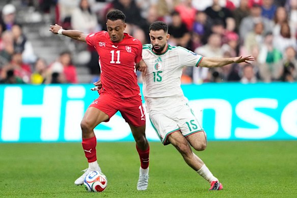 Switzerland’s Dan Ndoye (11) and Algeria’s Rayan Ait-Nouri (15) battle for the ball.