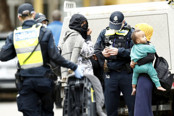 Police speaking to community members at one of the locked-down towers in North Melbourne on Saturday.