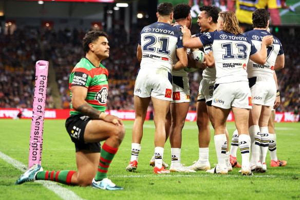 The Cowboys celebrate a try in front of a dejected Latrell Mitchell.