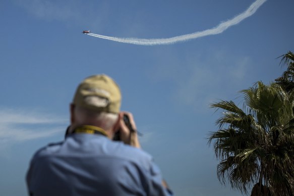 An onlooker watches a plane over St Kilda on Monday.