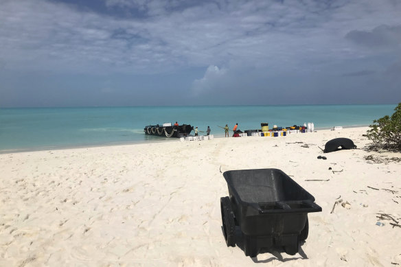 The crew unloads gear onto the beach as they arrive on Kure Atoll.