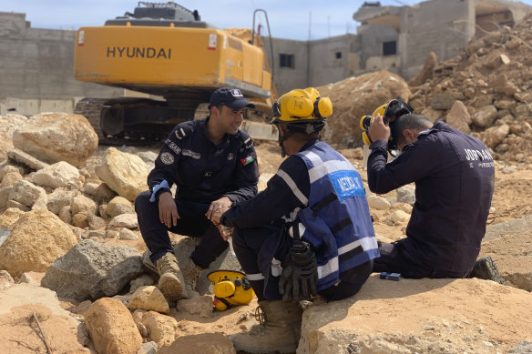 Rescue workers sit in front of an excavator in Derna, Libya.