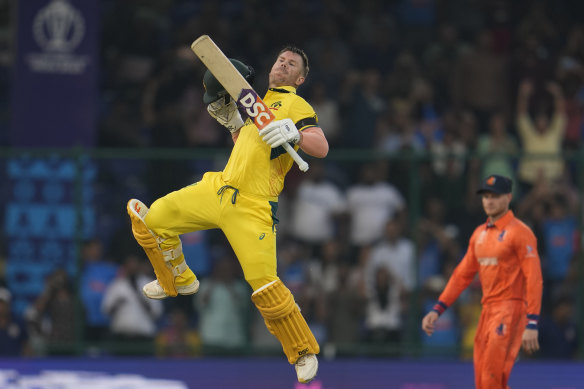 David Warner leaps to celebrate scoring a century.