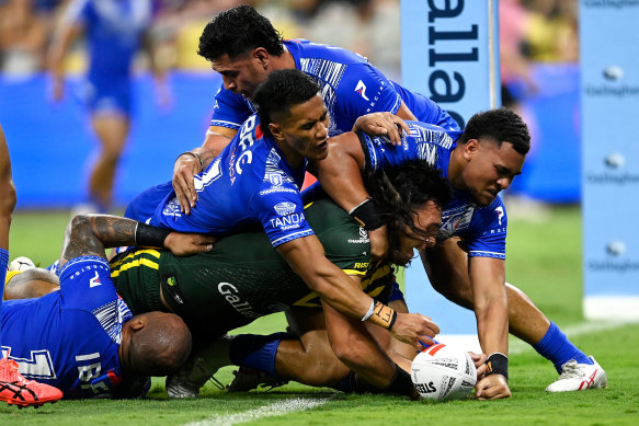 Tino Fa’asuamaleaui carries four Samoa defenders over the line to score for the Kangaroos.