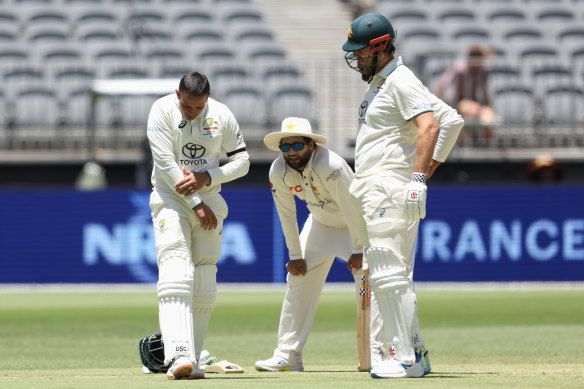 Usman Khawaja inspects the damage after copping a blow to his forearm.