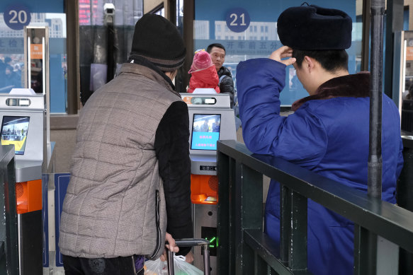 Train travellers use a facial recognition system to buy train tickets in Beijing.