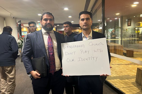 Khalid Amiri holds a protest placard outside the Dandenong Council meeting alongside Mash Ahmadzai on Monday night.
