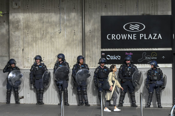 Riot police watch on during a subdued a second day of protests outside a weapons expo in Melbourne.