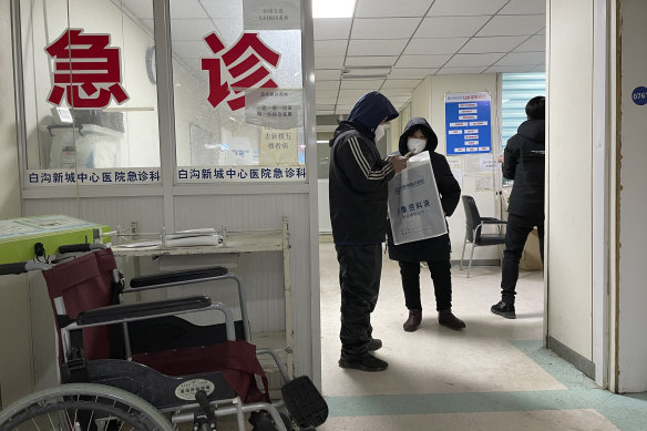 Visitors to the Baigou New Area Aerospace Hospital stand near the words “Emergency Clinic” in Baigou, in Hebei province.