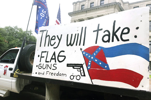 A protester outside the Mississippi Capitol says he wants to keep the Confederate battle emblem on the Mississippi state flag, which is shown on the large sign on the truck. 