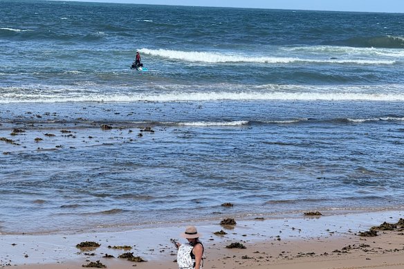 A surf lifesaver on a jet ski inspects the water at Dee Why on Monday afternoon.