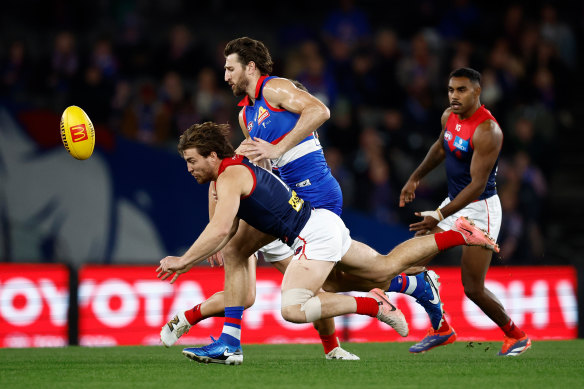 Melbourne midfielder Jack Viney is tackled by Marcus Bontempelli.