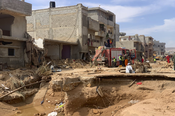 Rescue teams search for victims in Derna, Libya near a road that has been all but washed away.