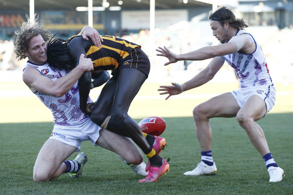 Changkuoth Jiath is tackled by the Dockers’ David Mundy.