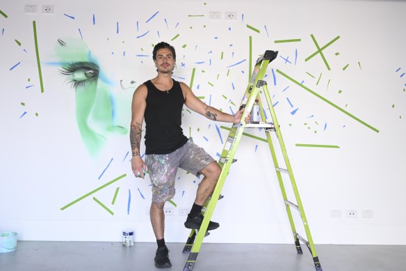 Monty Paink working on his mural at Melbourne Park.