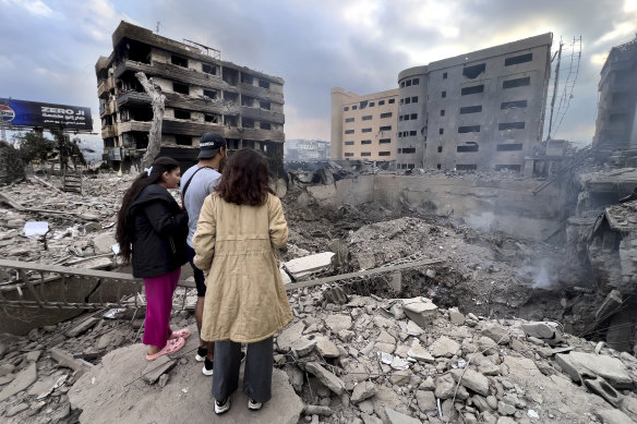 People look at destroyed buildings hit by Israeli airstrikes in Beirut, Lebanon. 