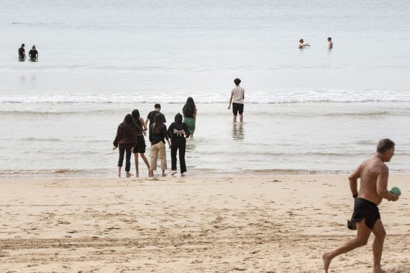 People enter the water cautiously at Manly Beach braving the cold air, Sydney, 30 June 2022