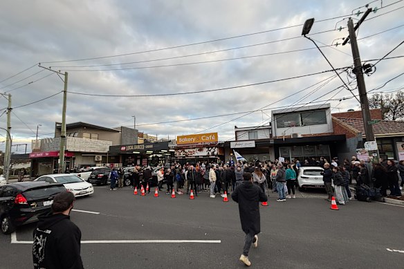 People gather at a snap rally outside a hair salon in Bentleigh.