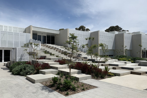 The unusual form reaches out to a northern courtyard that links to an existing school building.