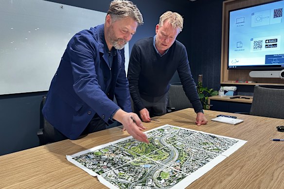 Prior + Partners director of master planning Jonathan Rose and Arcadis Brisbane Games and legacy lead Paul Allan look over a map of the Victoria Park site.