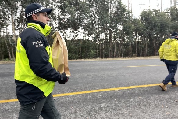 Police take evidence bags from the scene of a search at Mount Hotham on Wednesday.