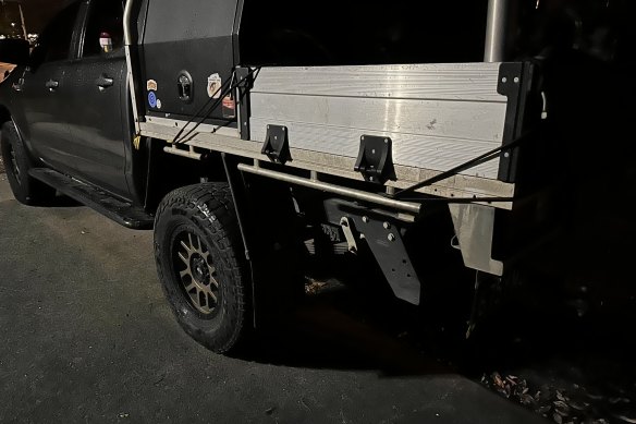 A ute with two of its wheels parked off the road in Brisbane.