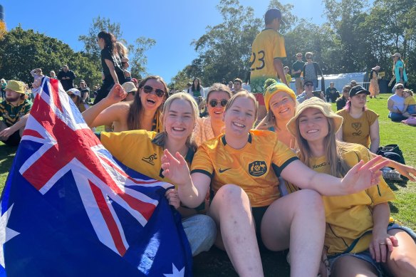 Sophie Bates (holding flag) and Maddy Francis (centre) with other Matildas fans at Riverstage on Sunday.