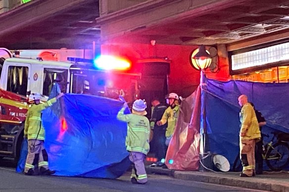 Firefighters used tarps to shield people from the confronting scene on Edward Street.