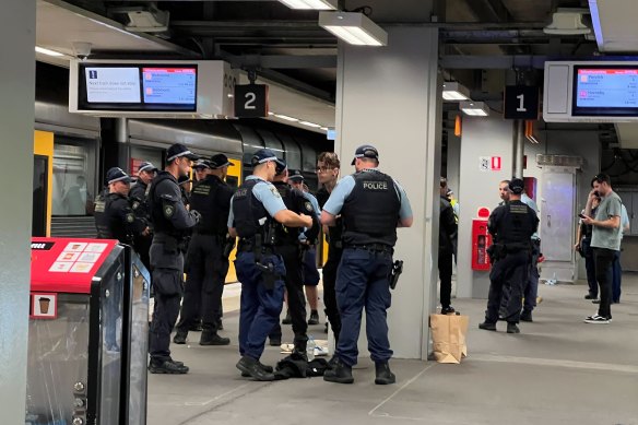 Police question a man at North Sydney station on Friday afternoon.