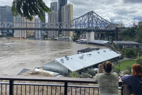 The view over a flooded Brisbane River and Howard Smith Wharves, only minutes before police gave an evacuation order due to a stray pontoon and crane.
