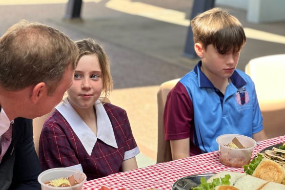 Premier Steven Miles sits with children at Cairns Meals on Wheels.