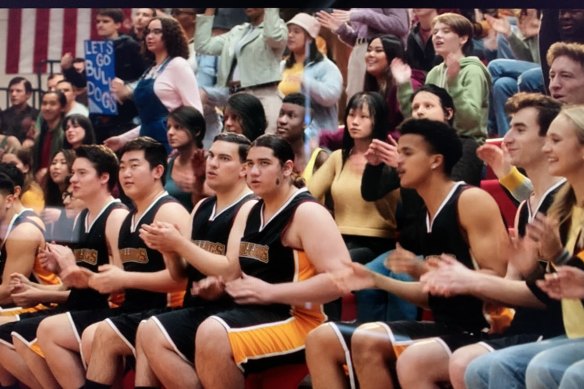 In this screen grab from the Disney+ movie Prom Pact, digital extras can be seen in the crowd, directly behind the basketball team.