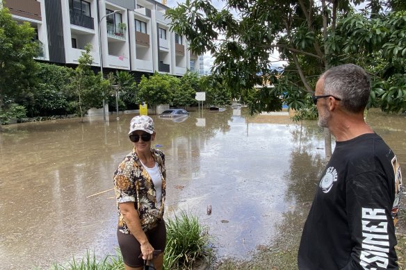 Rebecca and Jason Petzke look across to apartments where cars were flooded to their rooftops.