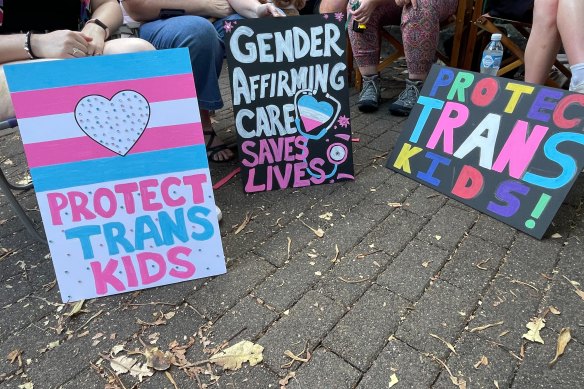 Signs held by trans attendees and parents of trans children. 
