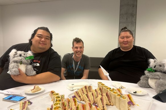 Reporter Jonathan Drennan is dwarfed by visiting Japanese sumo wrestlers in Sydney.