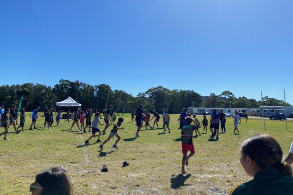Latrell Mitchell and Cody Walker play touch with local Cabbage Tree Island kids.