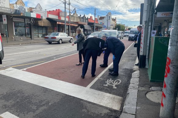 Forensic officers inspect a section of Sydney Road in Coburg on Thursday.