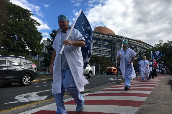 Workers strike outside Brisbane’s Princess Alexandra Hospital on Friday afternoon over the state government’s public service wage freeze in 2020.