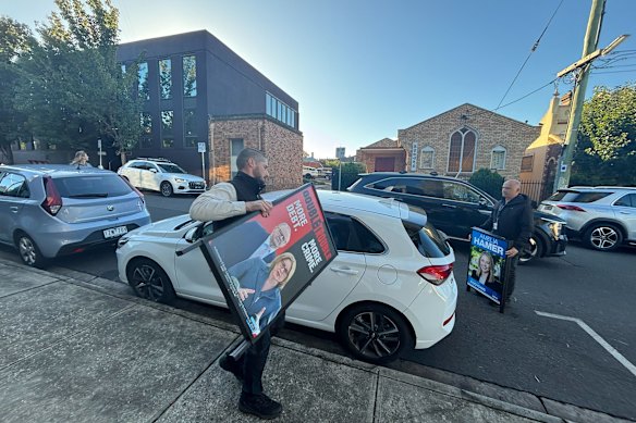 A council officer removing a Liberal Party sign in Kew on Wednesday morning.