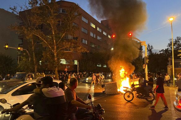 A police motorcycle and rubbish bin burn during a protest over the death of Mahsa Amini, a 22-year-old woman who had been detained by the nation’s morality police, in downtown Tehran, Iran on September 24.