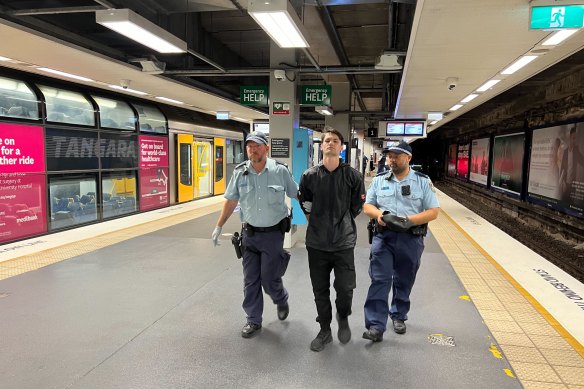 A man is escorted from North Sydney station on Friday.