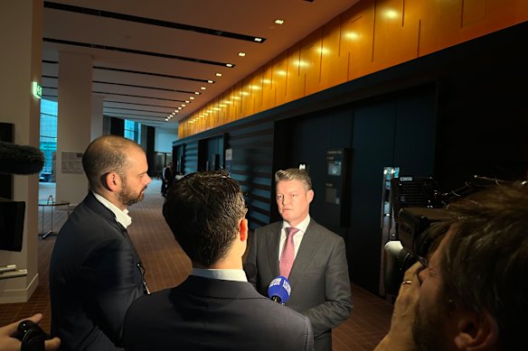 Ben Carroll speaks to reporters in the foyer following his address.