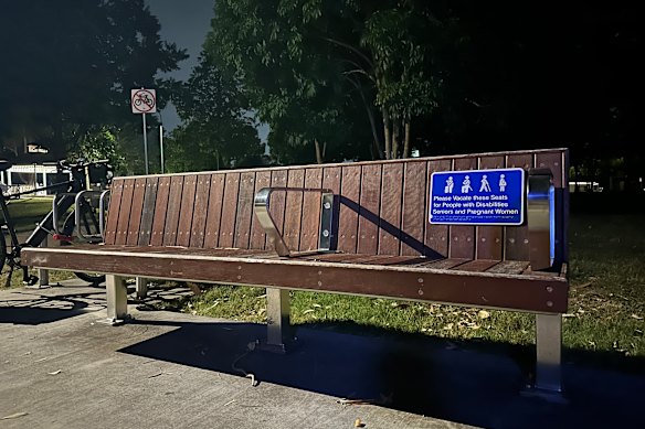 A handrail in the middle of this bench makes it difficult for someone to sleep here.