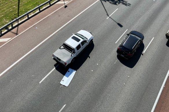 Cars swerve to avoid debris from the truck in the Mitchell Freeway’s northbound lane.
