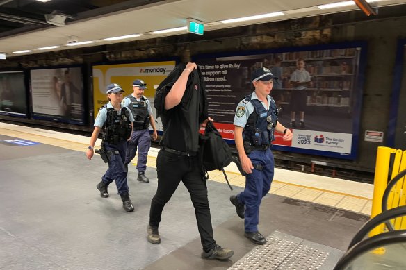 A man is escorted from North Sydney railway station on Australia Day.